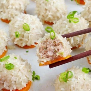 A half pearl meatball held by chopsticks.