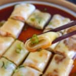 a piece of Cheung fun held by chopsticks