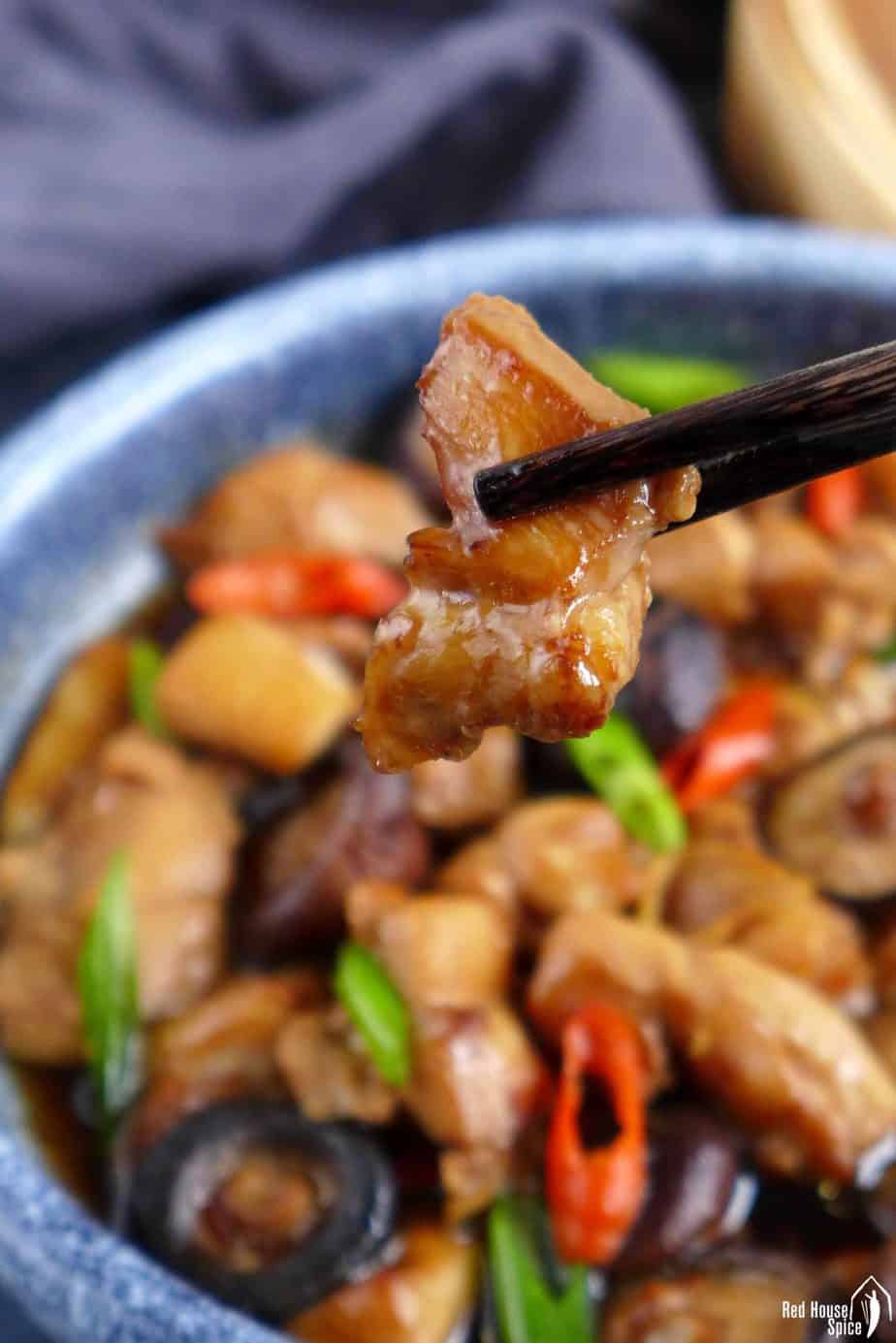 chopsticks picking up a piece of chicken