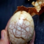 one half peeled tea egg.