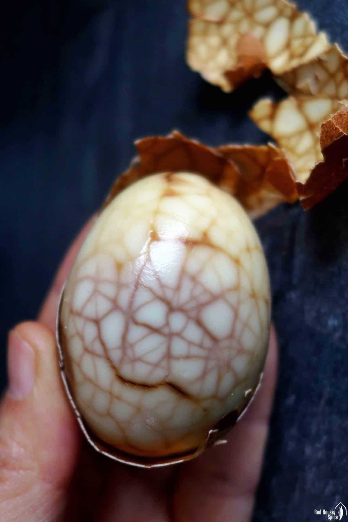 one half peeled tea egg.