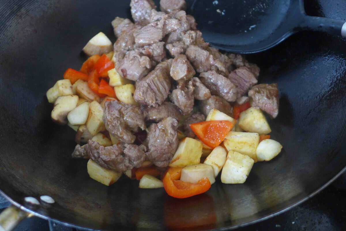 adding beef to vegetables.