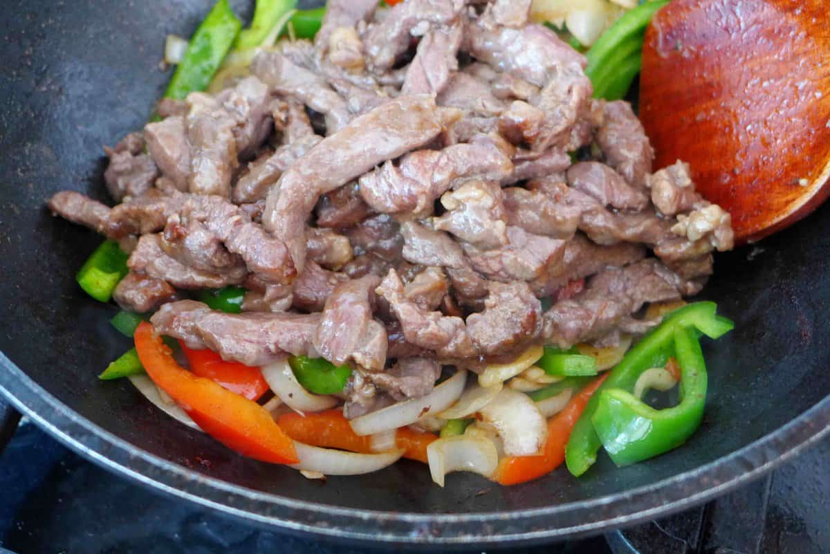 adding beef to veggies.