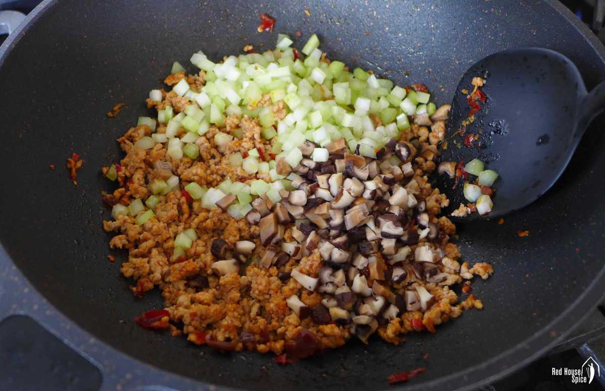 adding celery and mushroom to minced pork