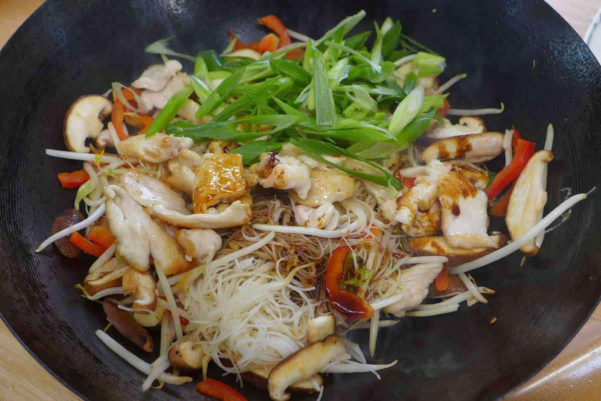adding sauce to chow mei fun.
