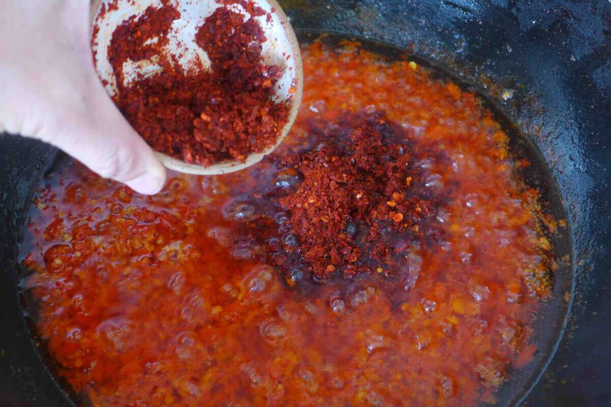 adding chili flakes to fried chili and garlic.