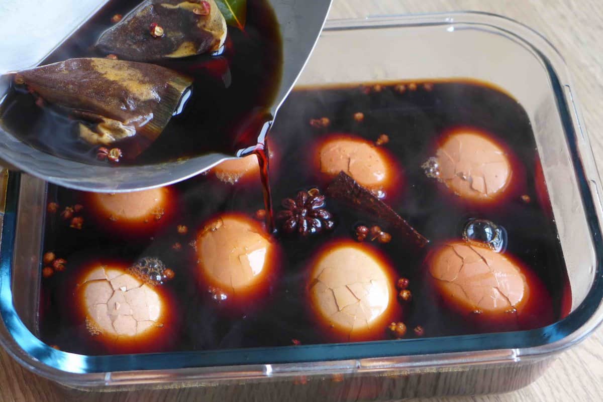 adding marinade to boiled and cracked eggs.