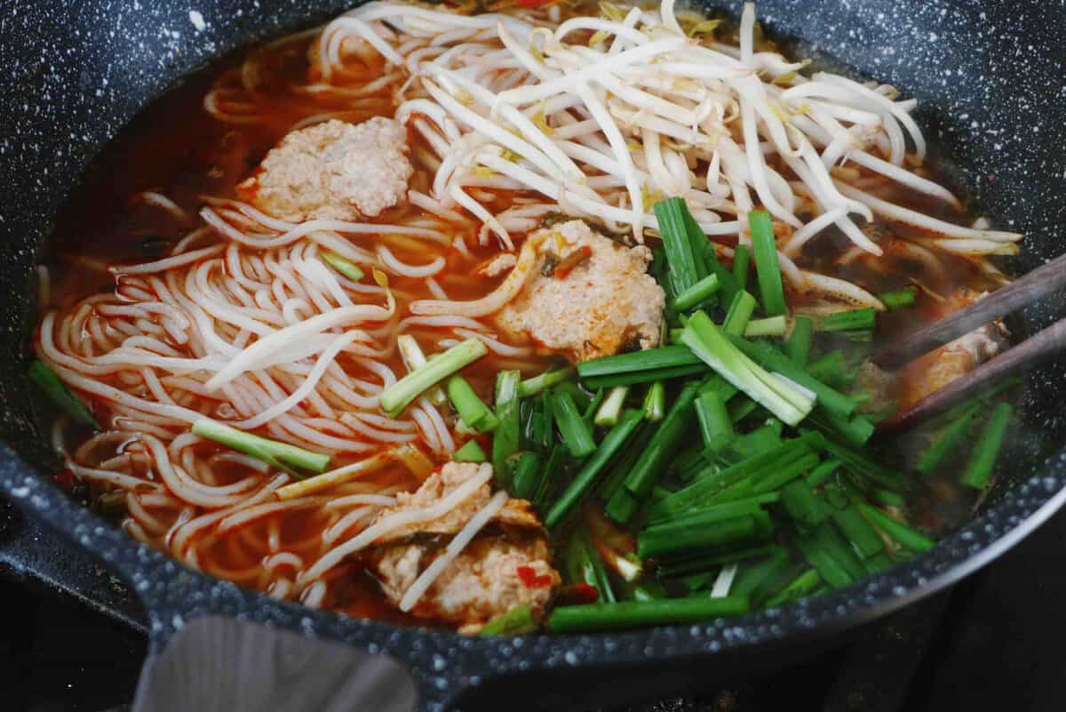 cooking noodles and vegetables in soup.