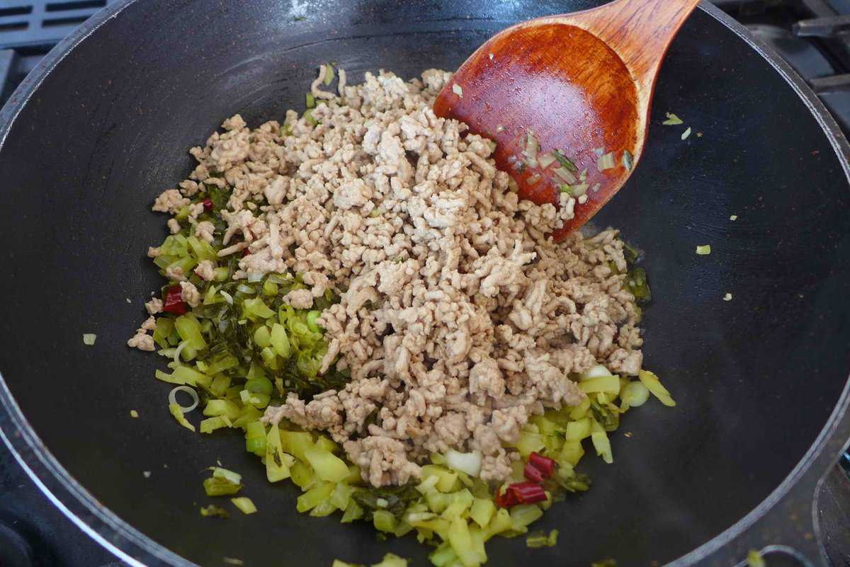 adding cooked ground pork to pickled mustard greens.