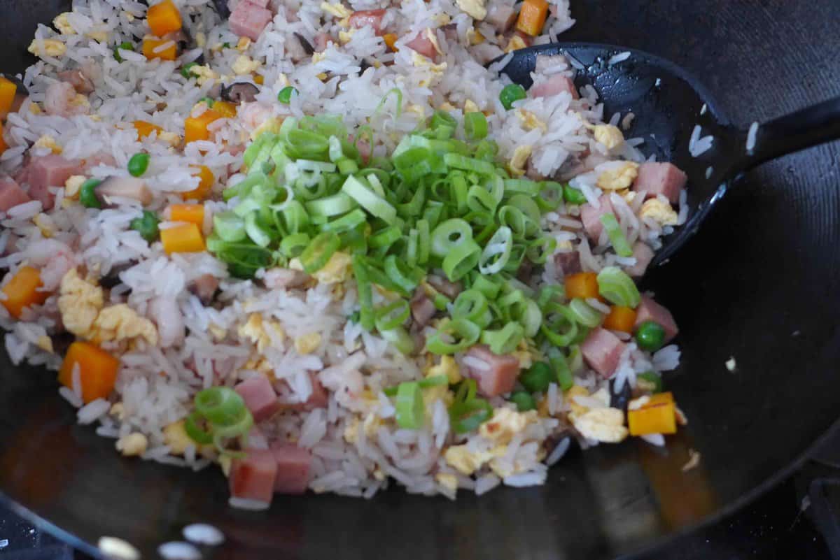 adding scallions to fried rice.