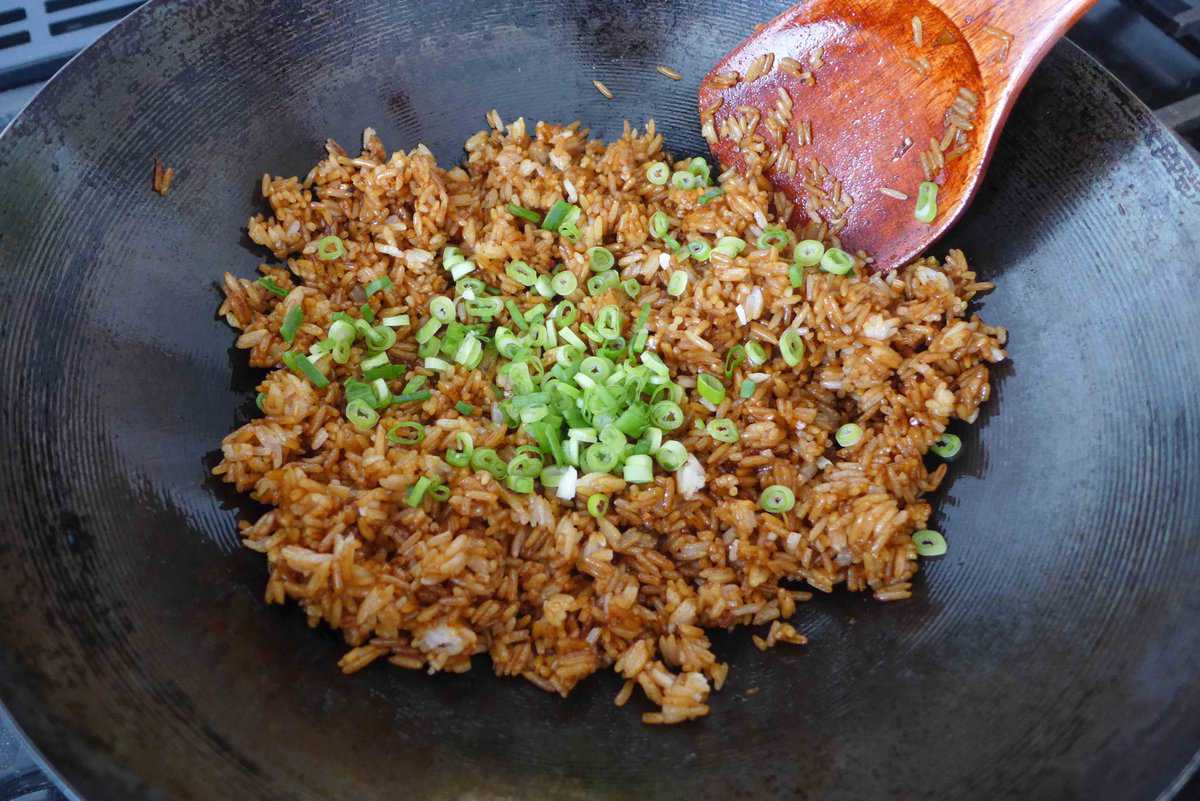 adding scallions to fried rice.
