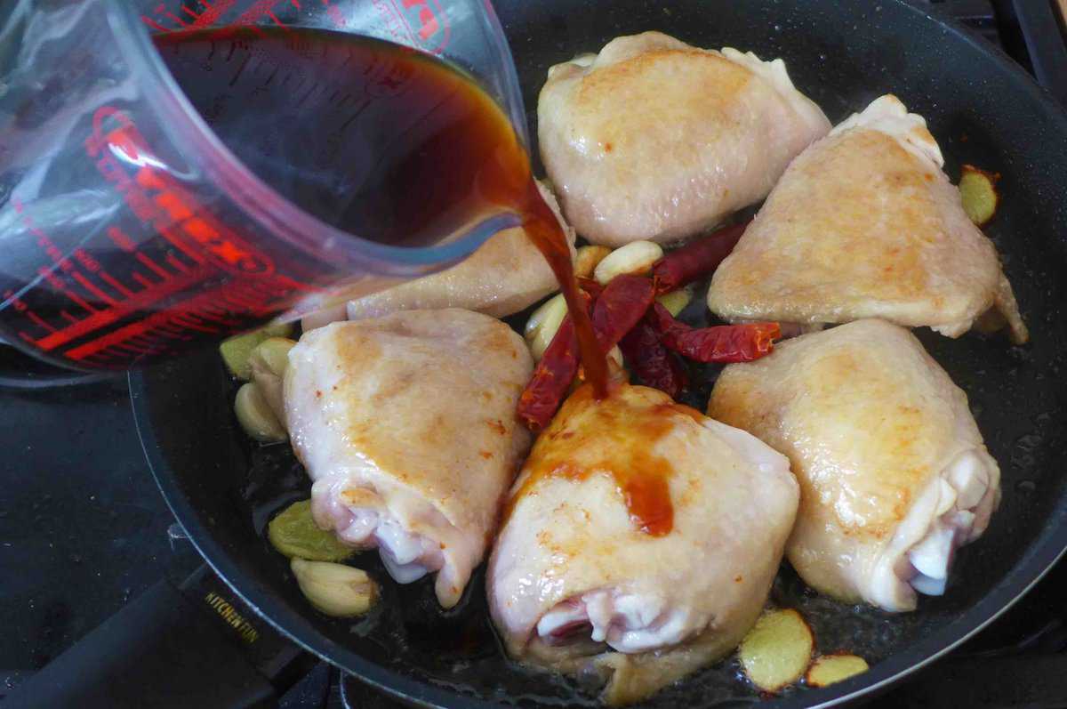 pouring seasoning liquid over chicken.