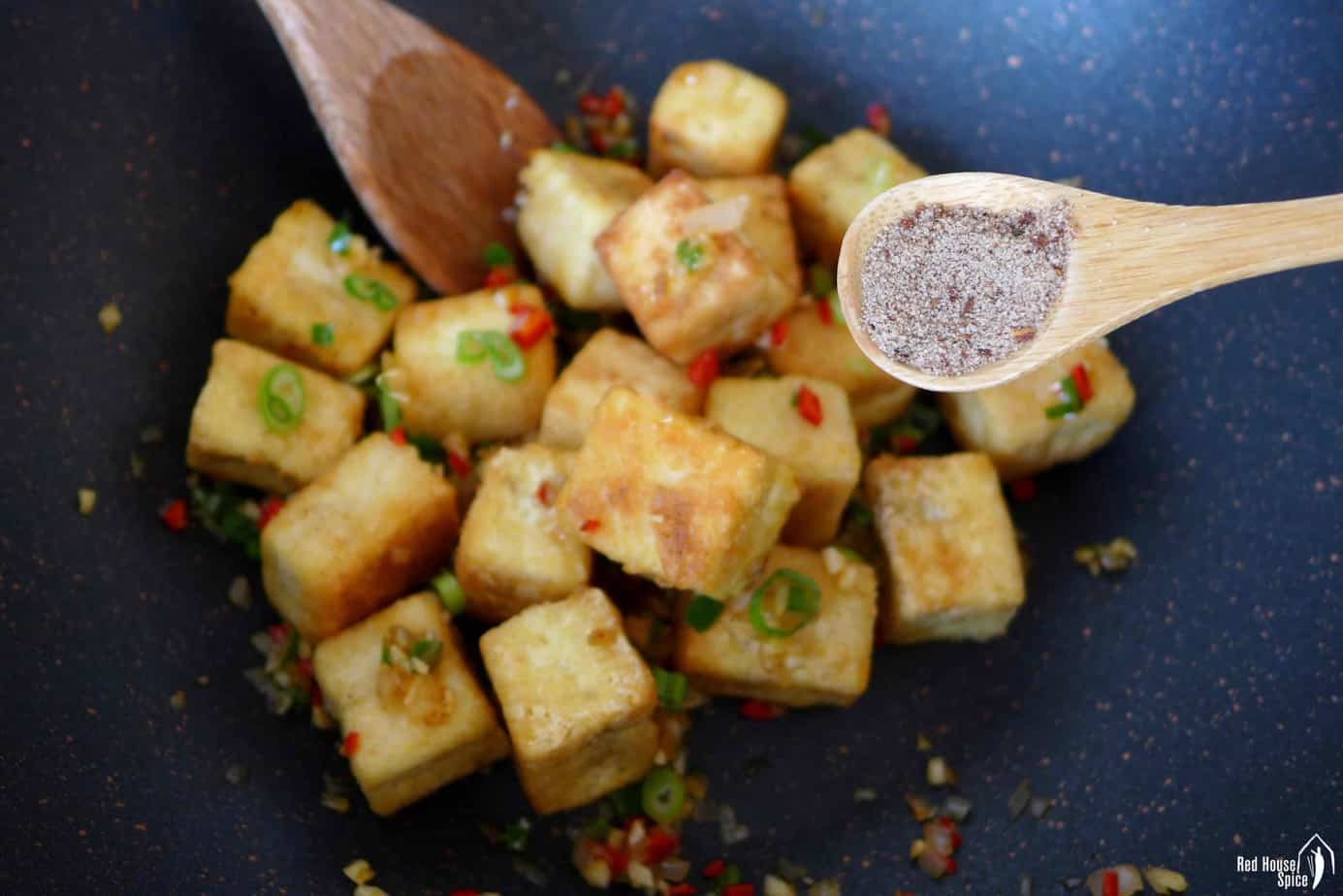 adding salt and pepper seasoning fried tofu
