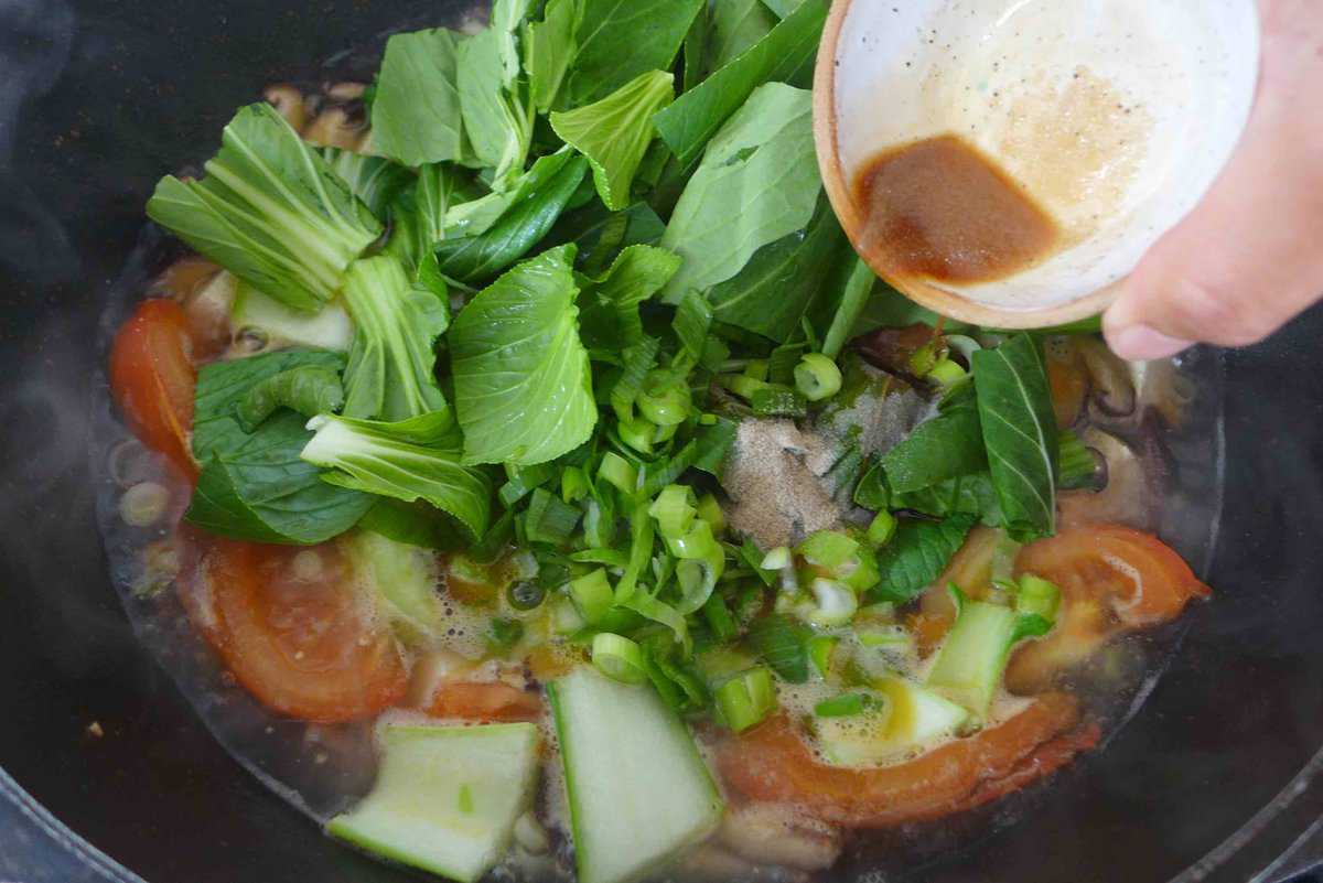 adding seasonings to tofu soup.