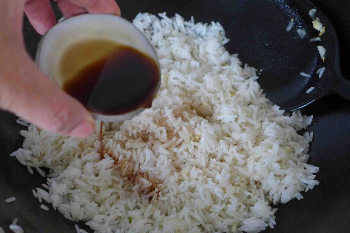 adding soy sauce to rice.