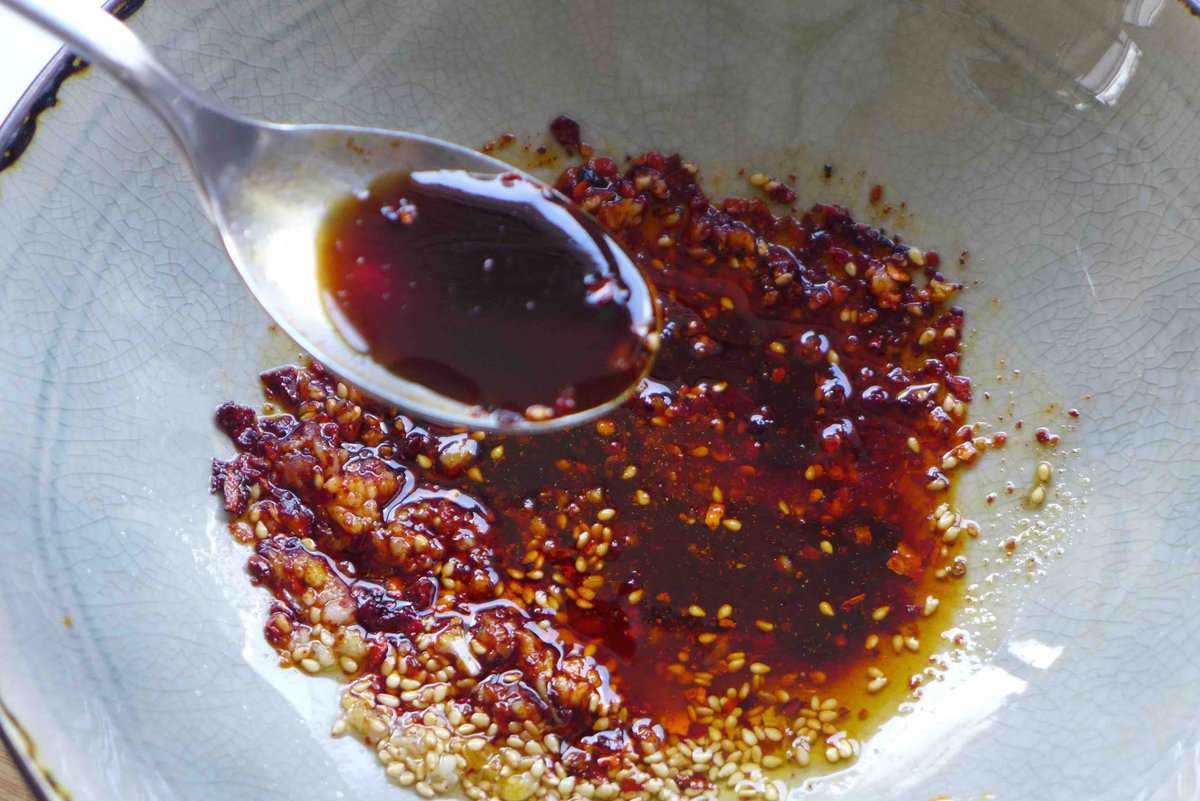 adding soy sauce to a bowl.