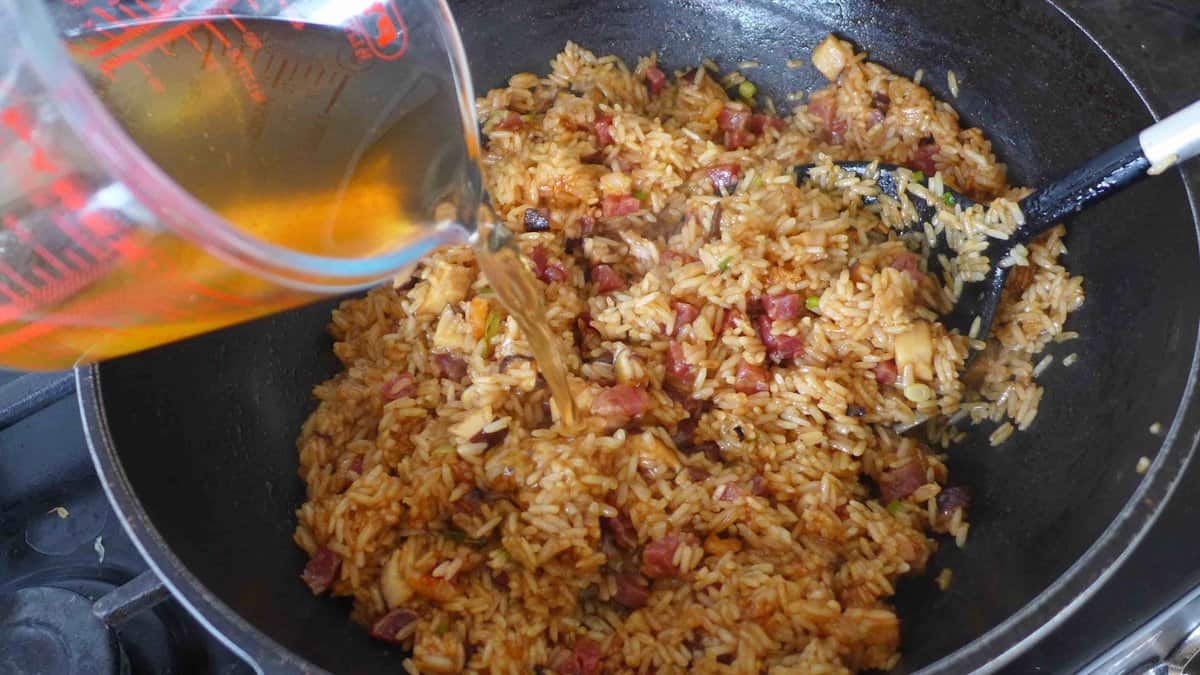 adding liquid to half-cooked glutinous rice.