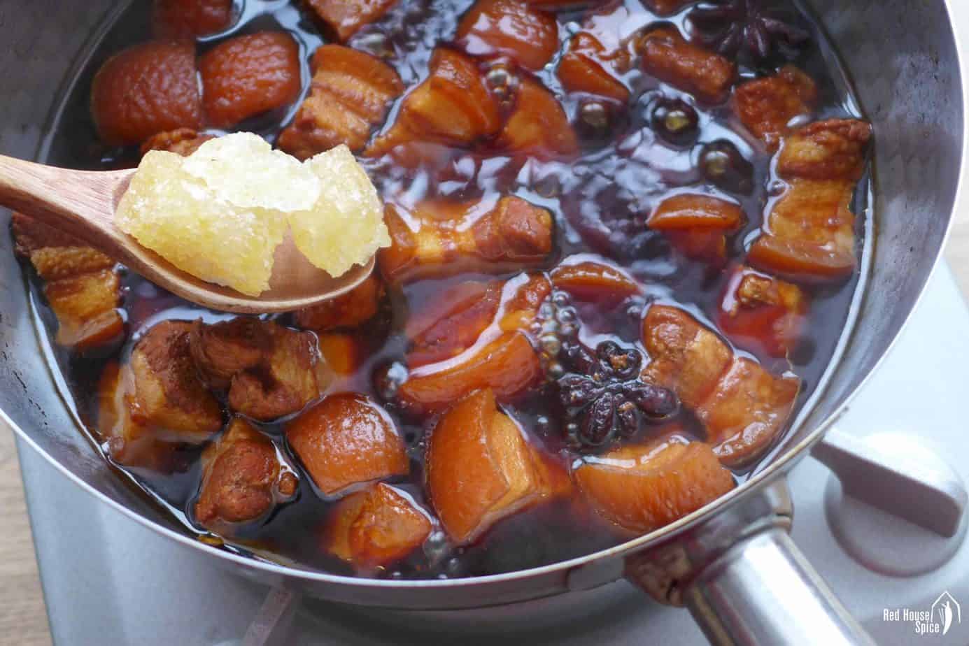 adding rock sugar into braised pork