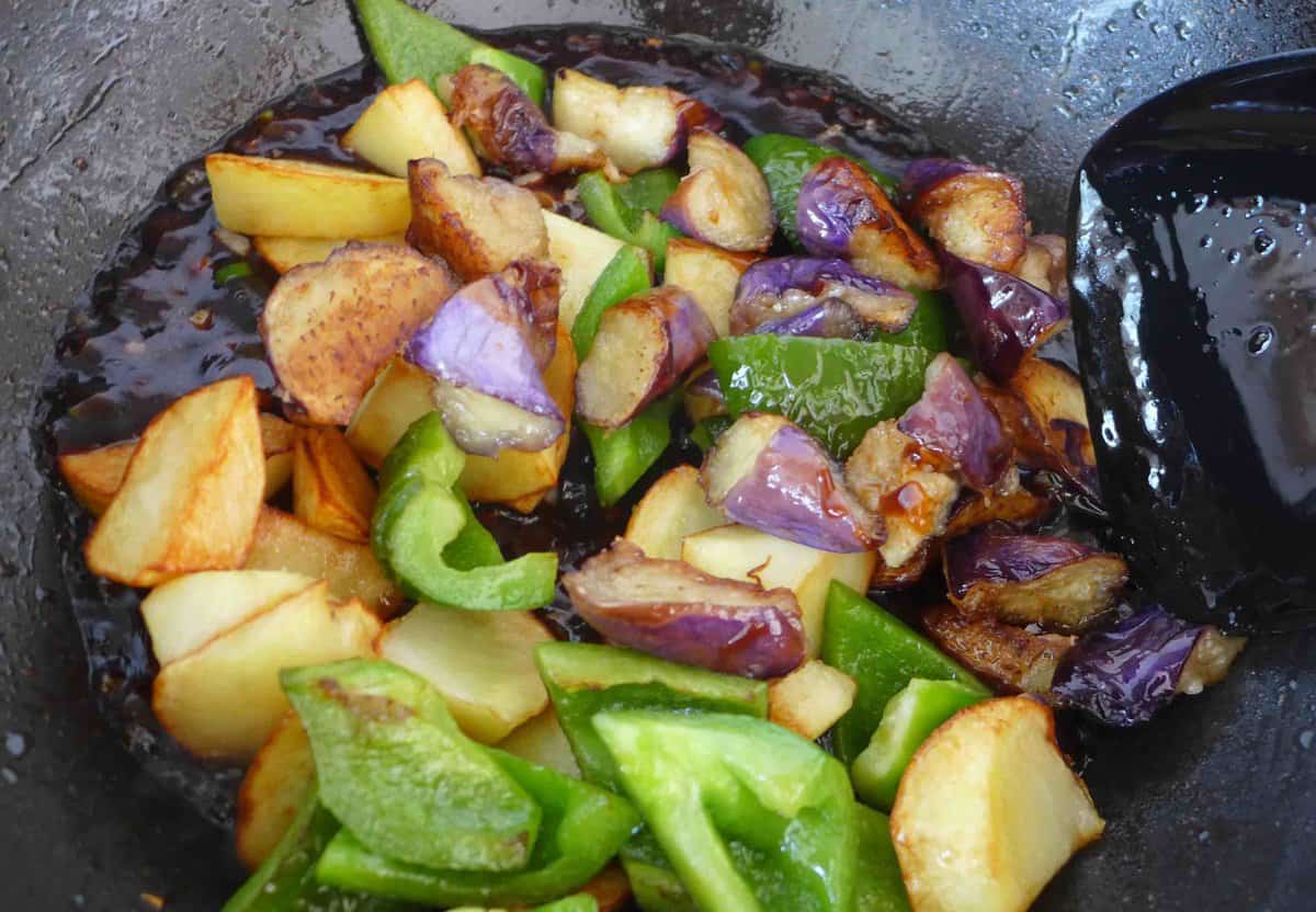 adding fried eggplant, potato and pepper to sauce.