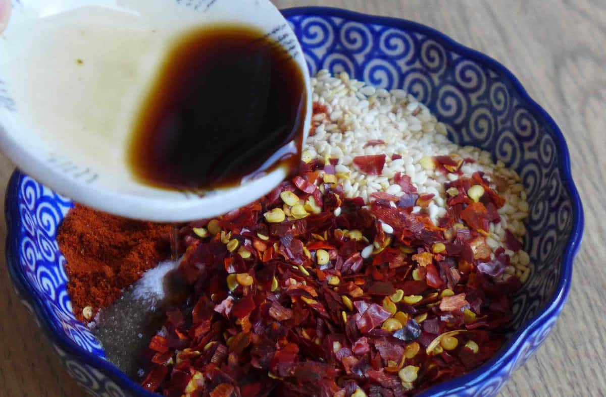 Pouring vinegar over chili flakes.