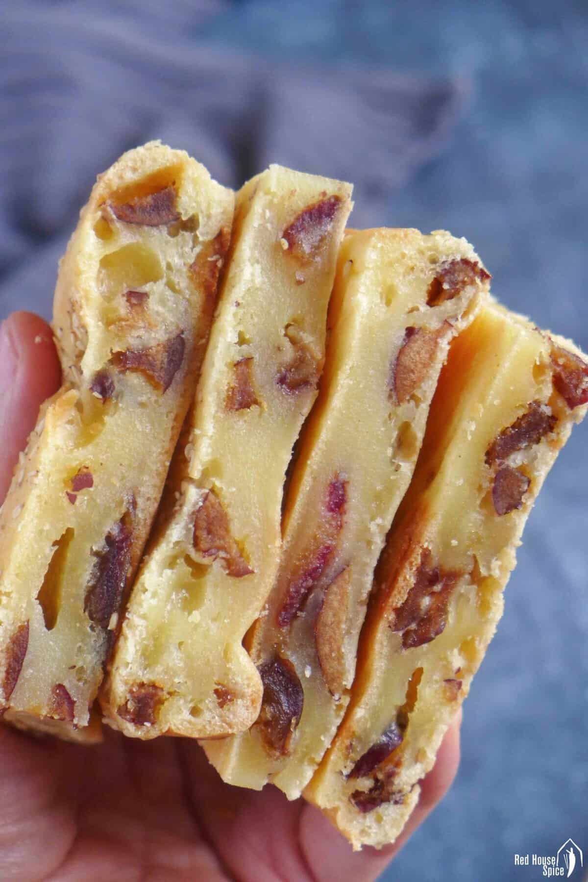baked rice caked with dates held by hand.