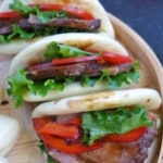 folded bao buns with beef and vegetable filling.