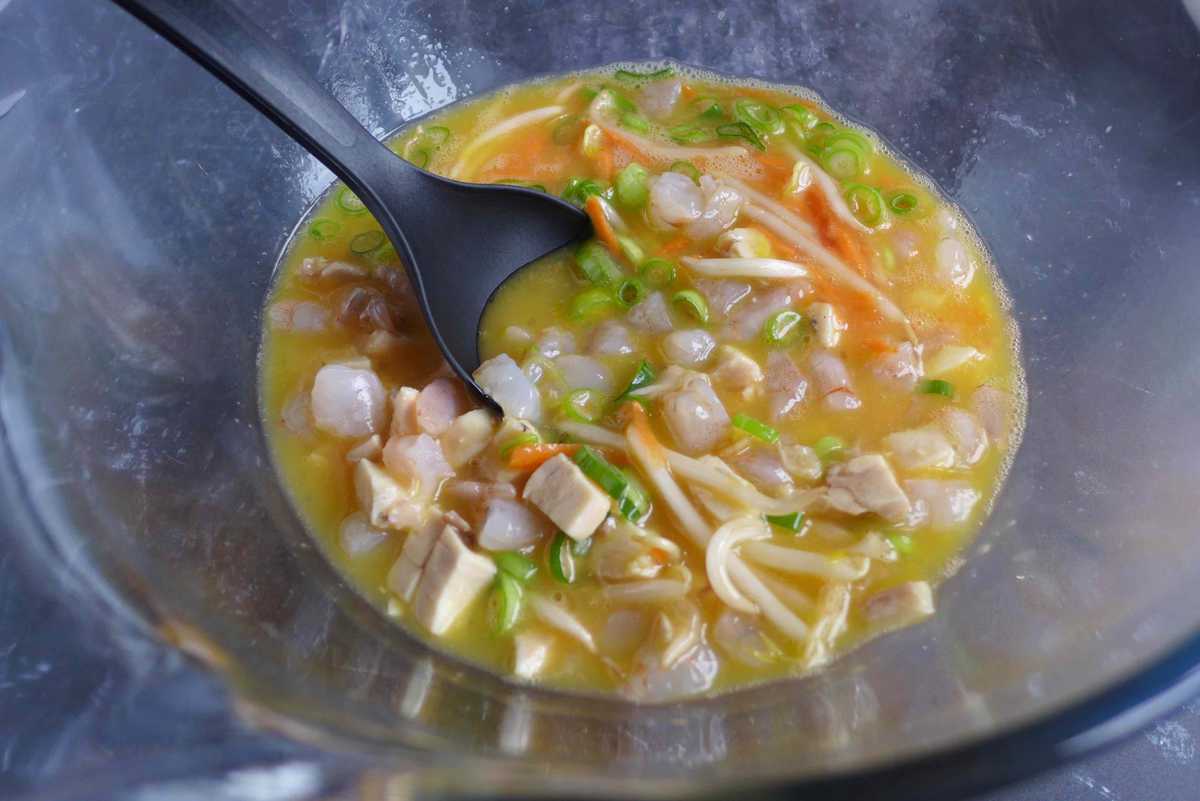 beaten eggs mixed with chicken, shrimp and vegetables