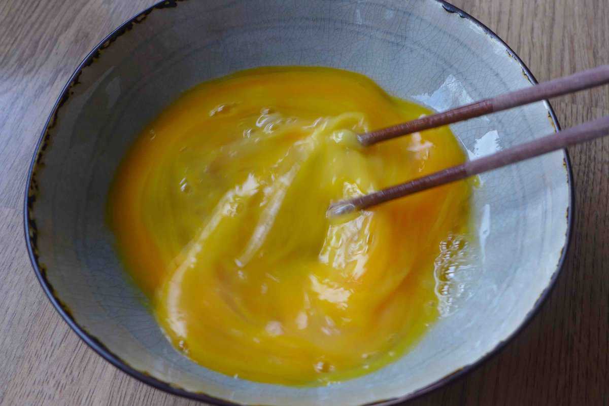 beating eggs with chopsticks.