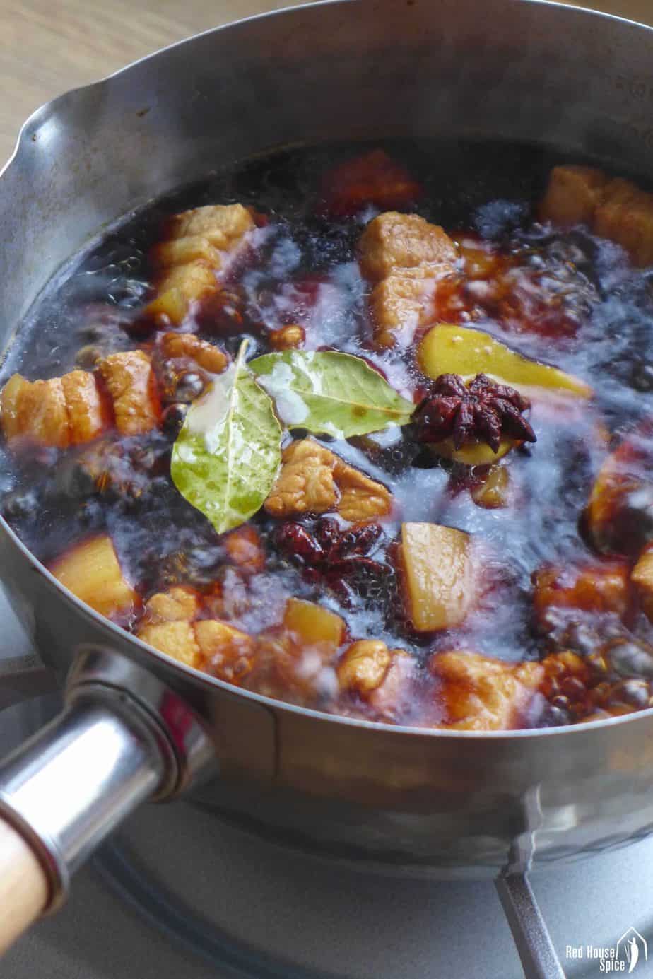 boiling pork chunks in a dark broth