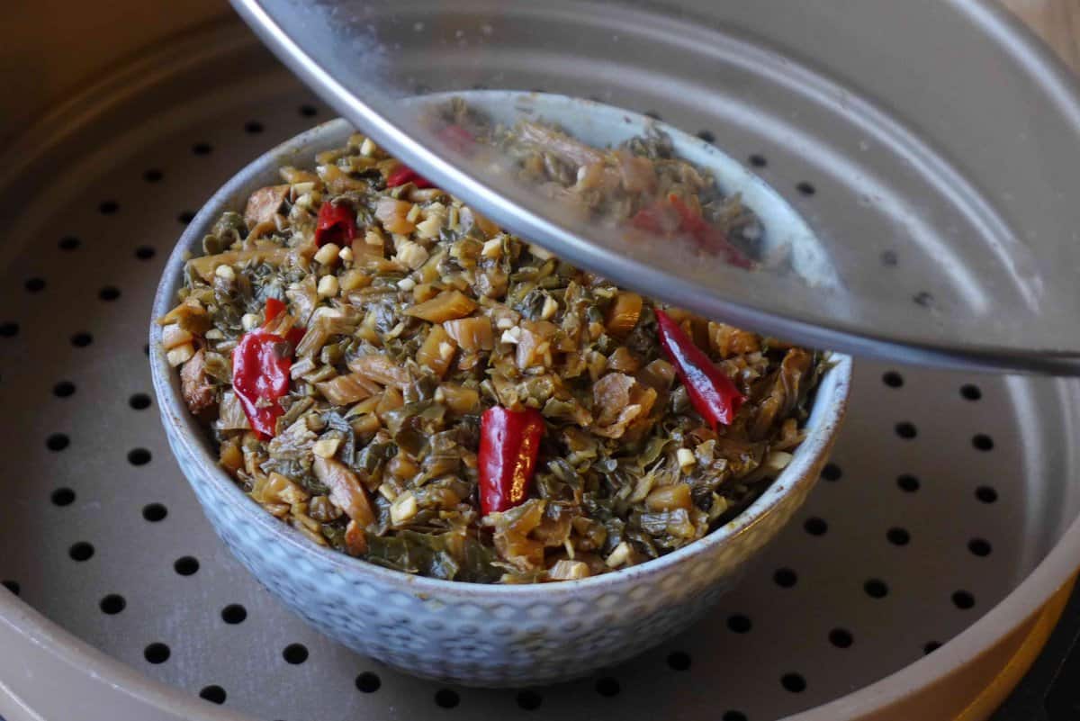 a bowl filled with braised Mei Cai in a steamer.