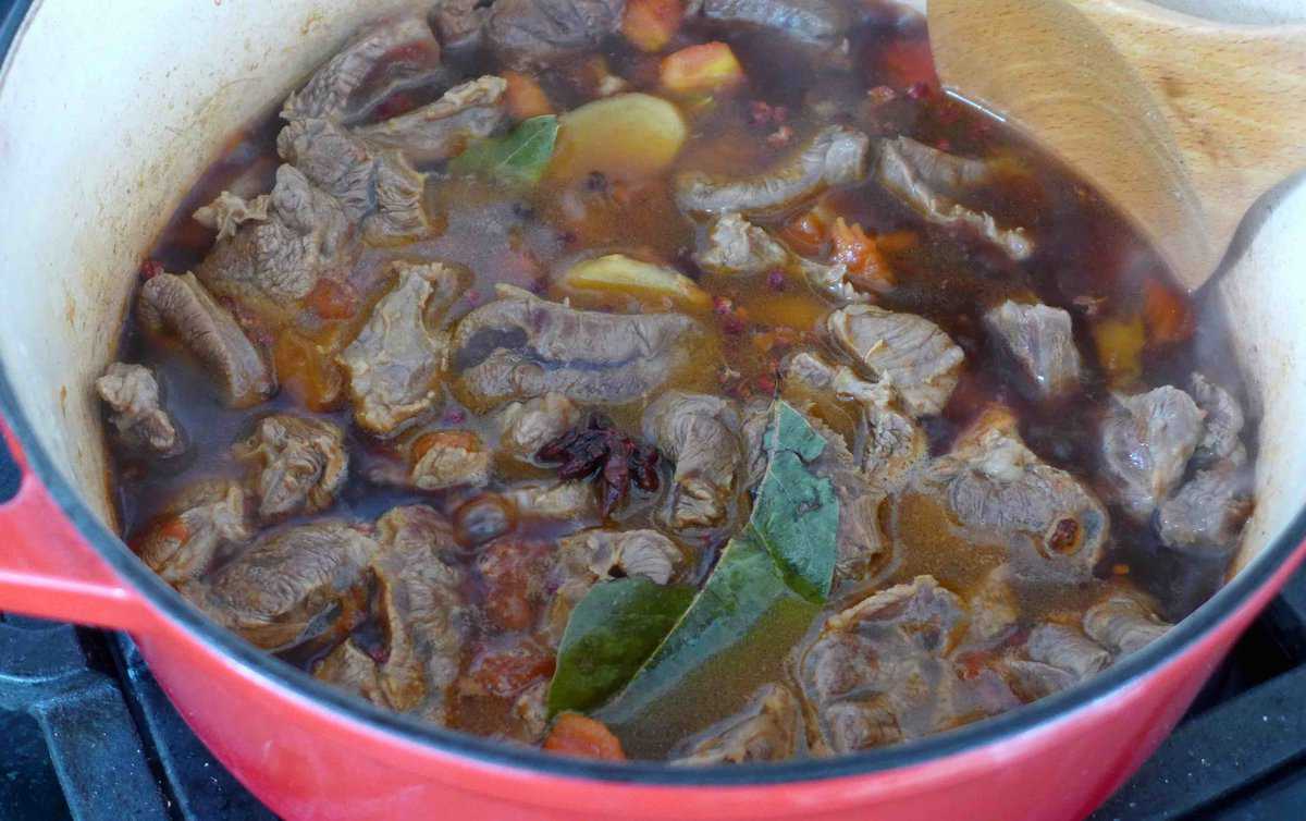 beef, spiced and sauce with water in a pot.
