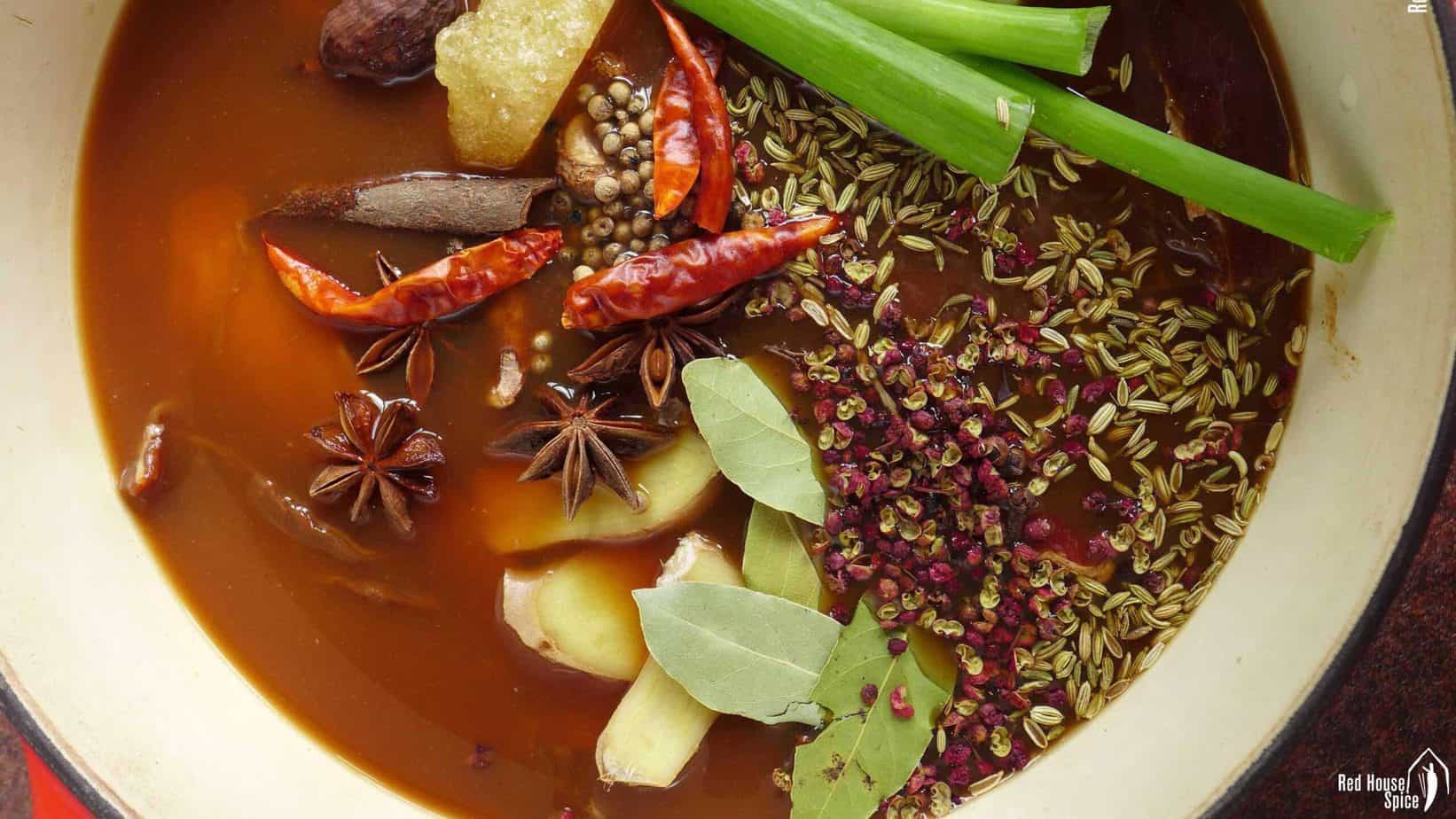 A pot of broth with spices