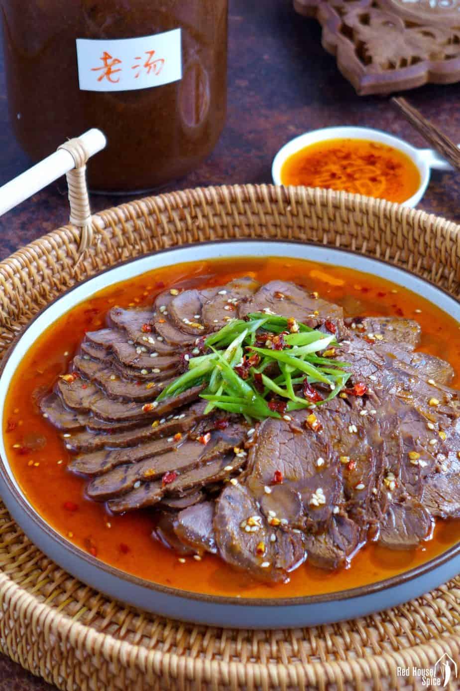A plate of beef slices and a jar of beef stock