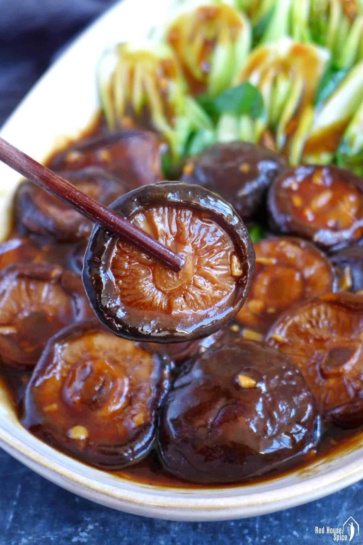 a shiitake mushroom held by chopsticks