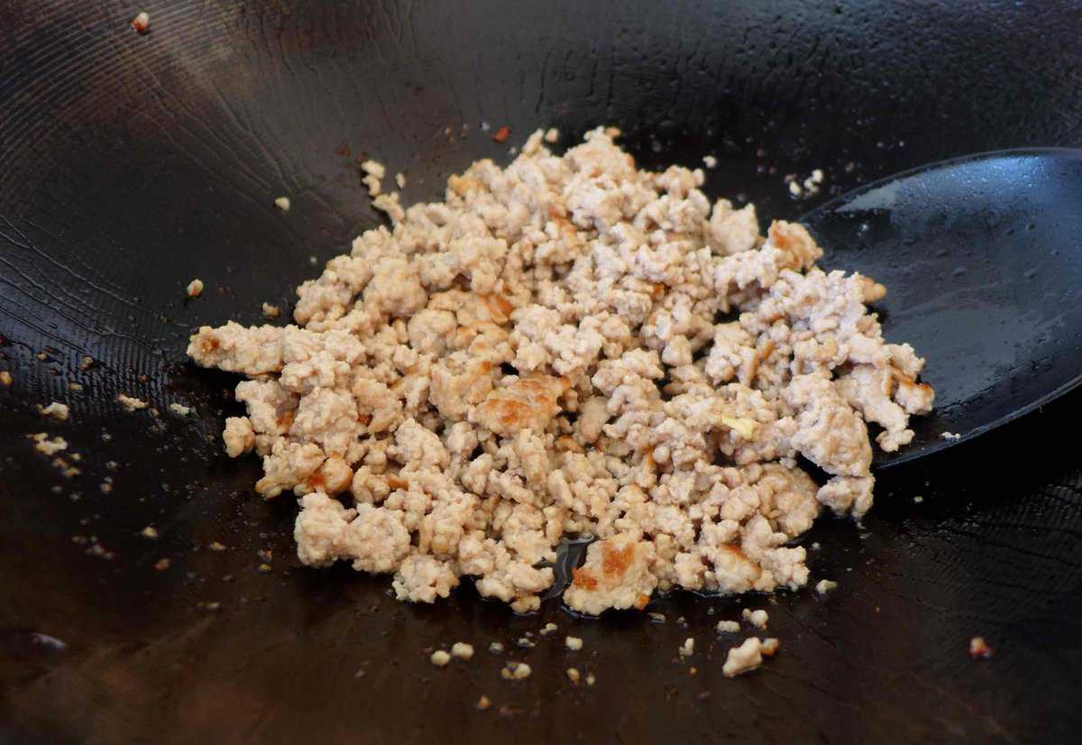 frying minced pork in a wok