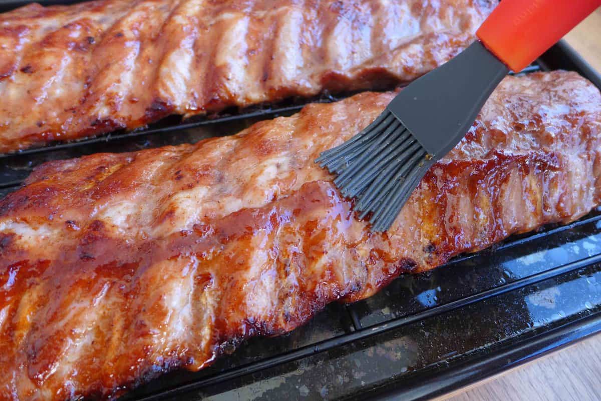 brushing honey over cooked ribs.