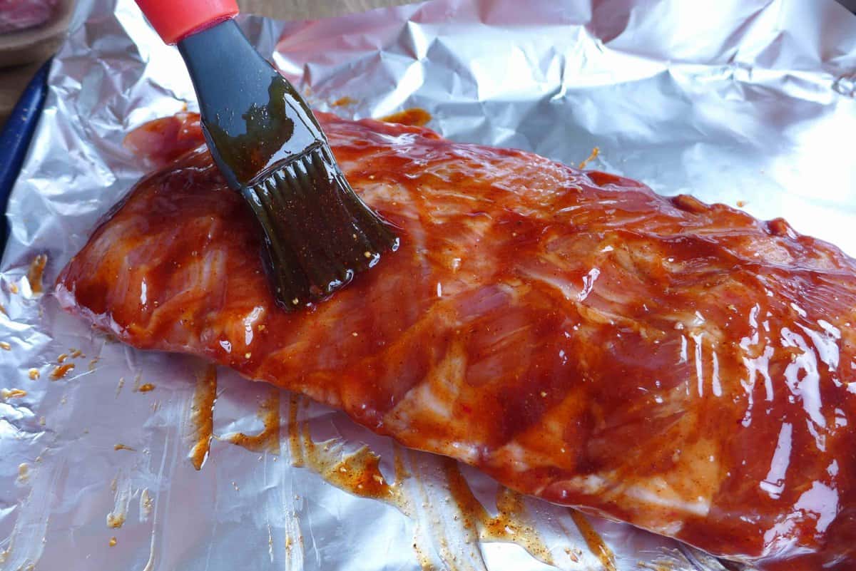 brushing marinade over ribs.