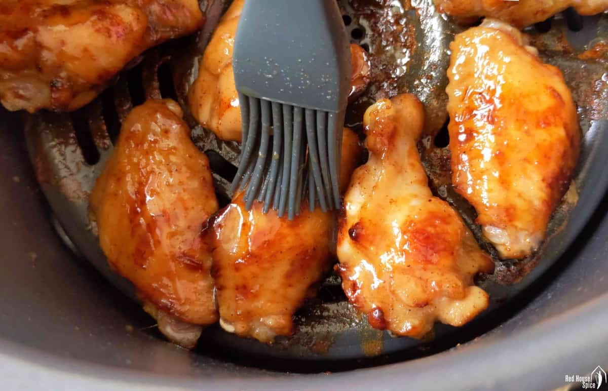 brushing sauce over chicken wings