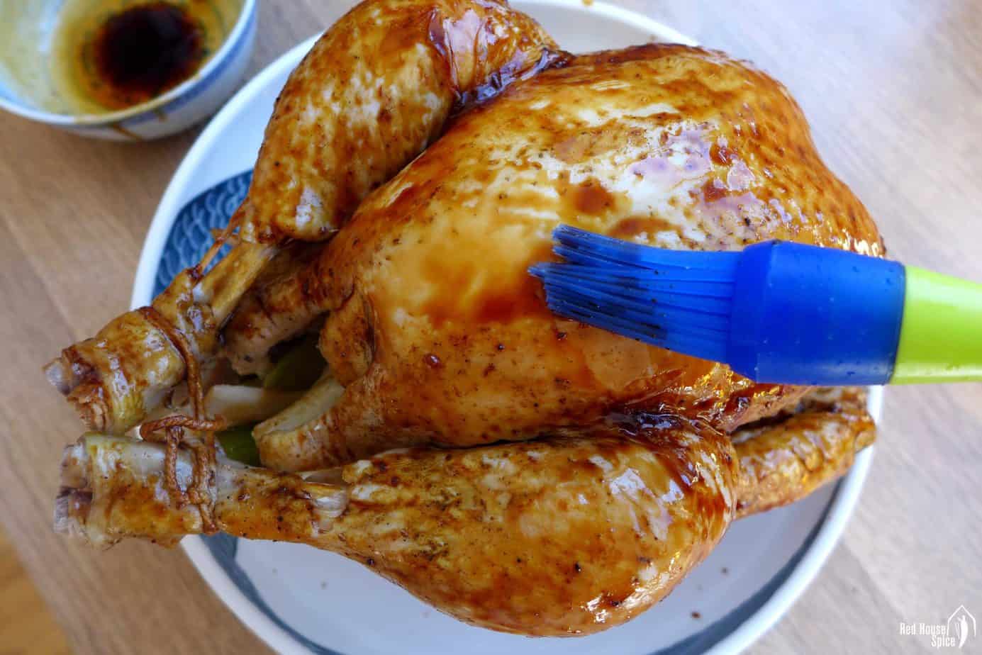 Brushing sauce over a chicken