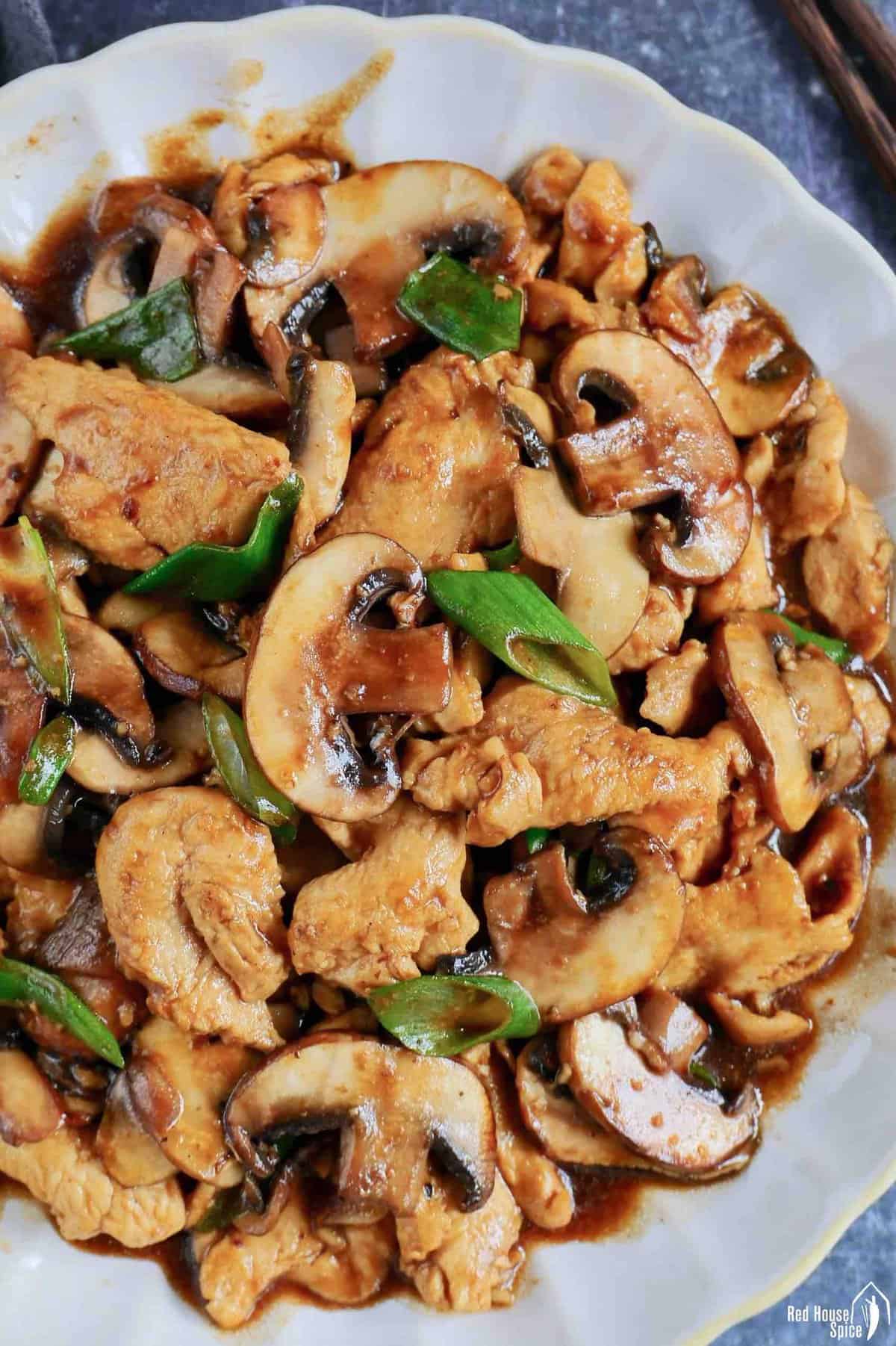 Stir-fried chicken slices and button mushrooms.