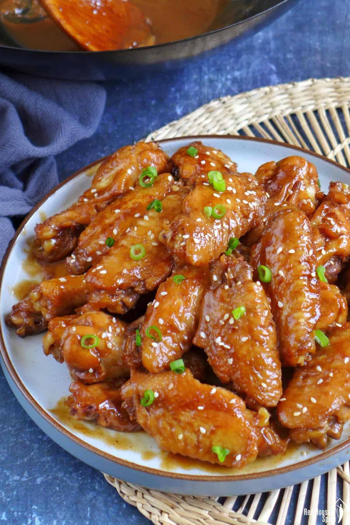 Coca Cola chicken wings garnished with scallions and sesame seeds