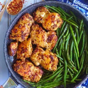 chili cumin chicken thighs and green beans in a skillet.