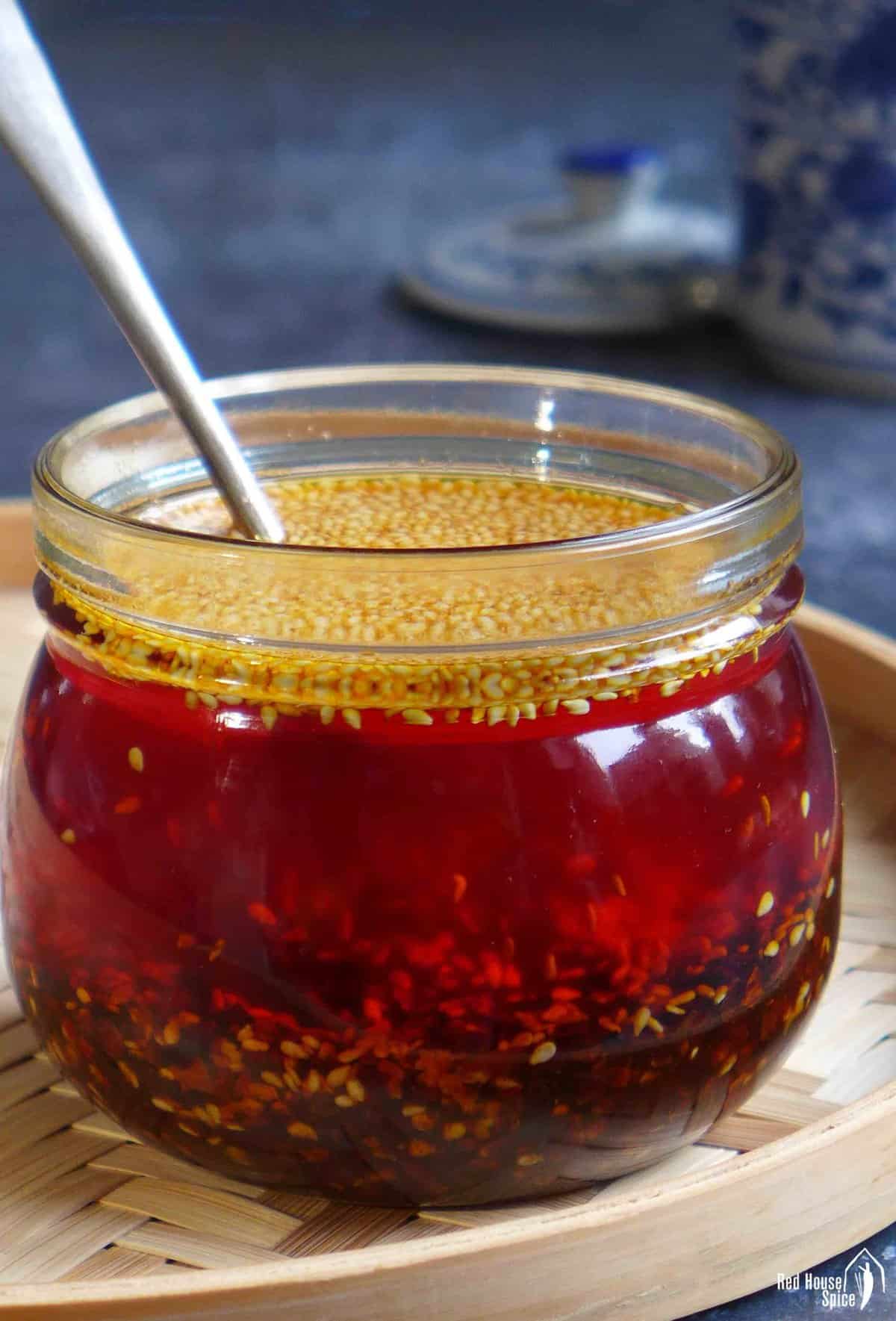 Chili oil in a jar with a spoon.