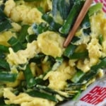 chopsticks picking up stir-fried chinese chive and egg.