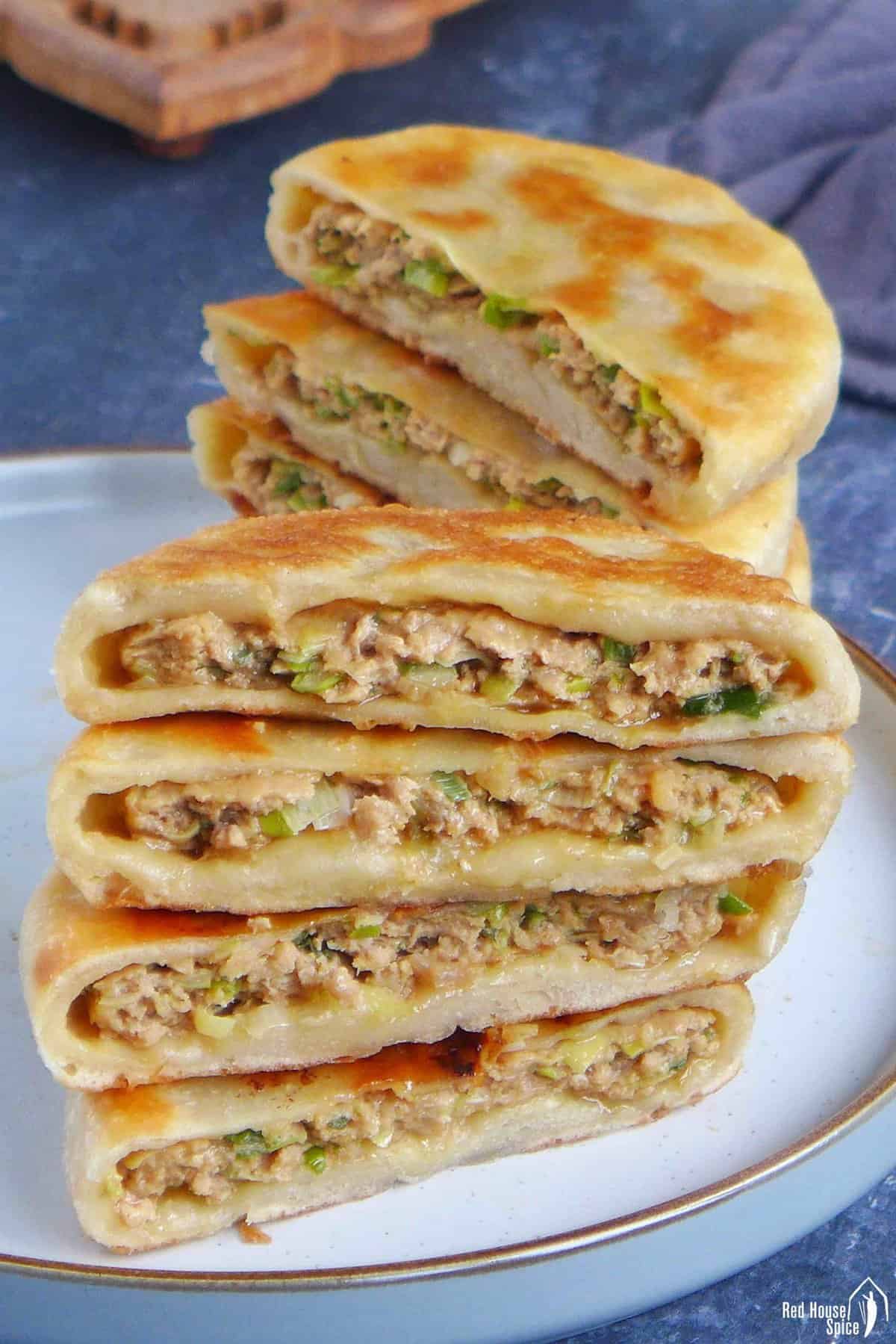 halved Chinese meat pies showing the filling inside.