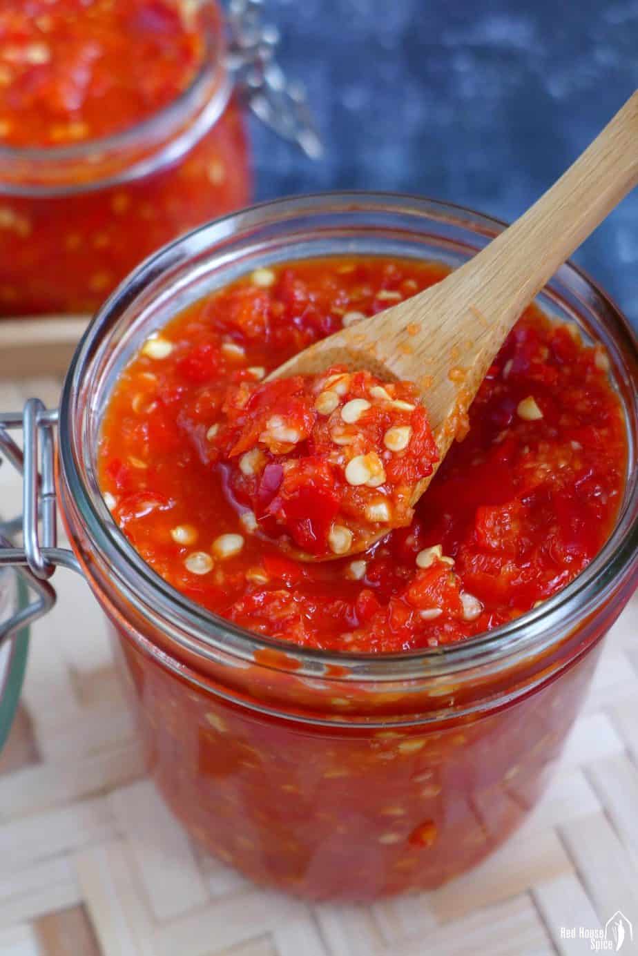 Spoon scooping out some pickled chili garlic sauce