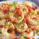 deep fried squid rings with aromatics with overlay text that says salt and pepper squid