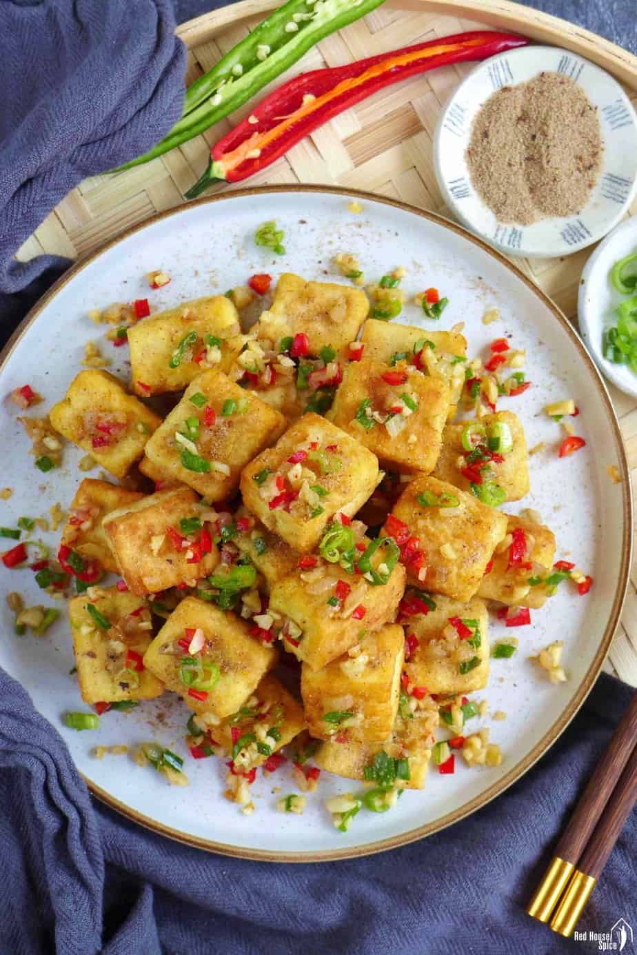 A plate of Chinese salt and pepper tofu with salt and pepper seasoning on the side