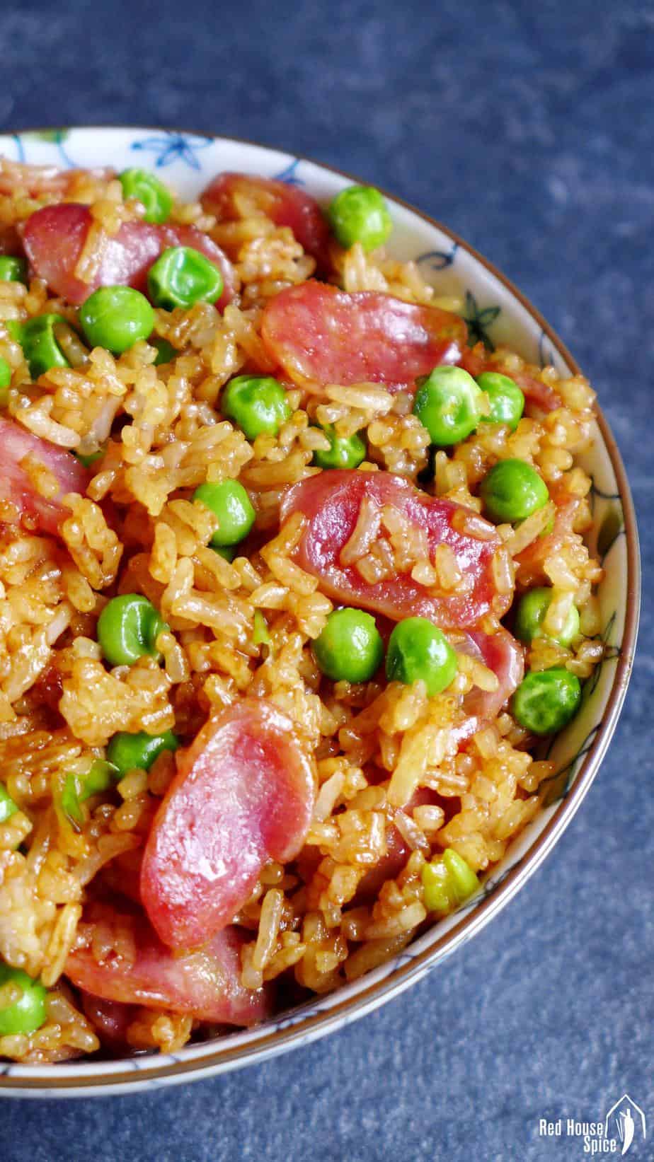 A bowl of fried rice with sliced Chinese sausage