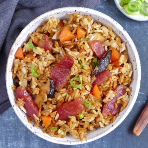 Chinese sausage rice with carrots and mushroom in a bowl.